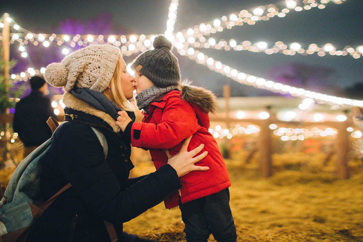 Mom and son kissing at a holiday light show