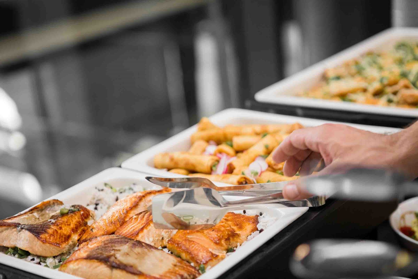 Man adding food to his plate at a seafood buffet