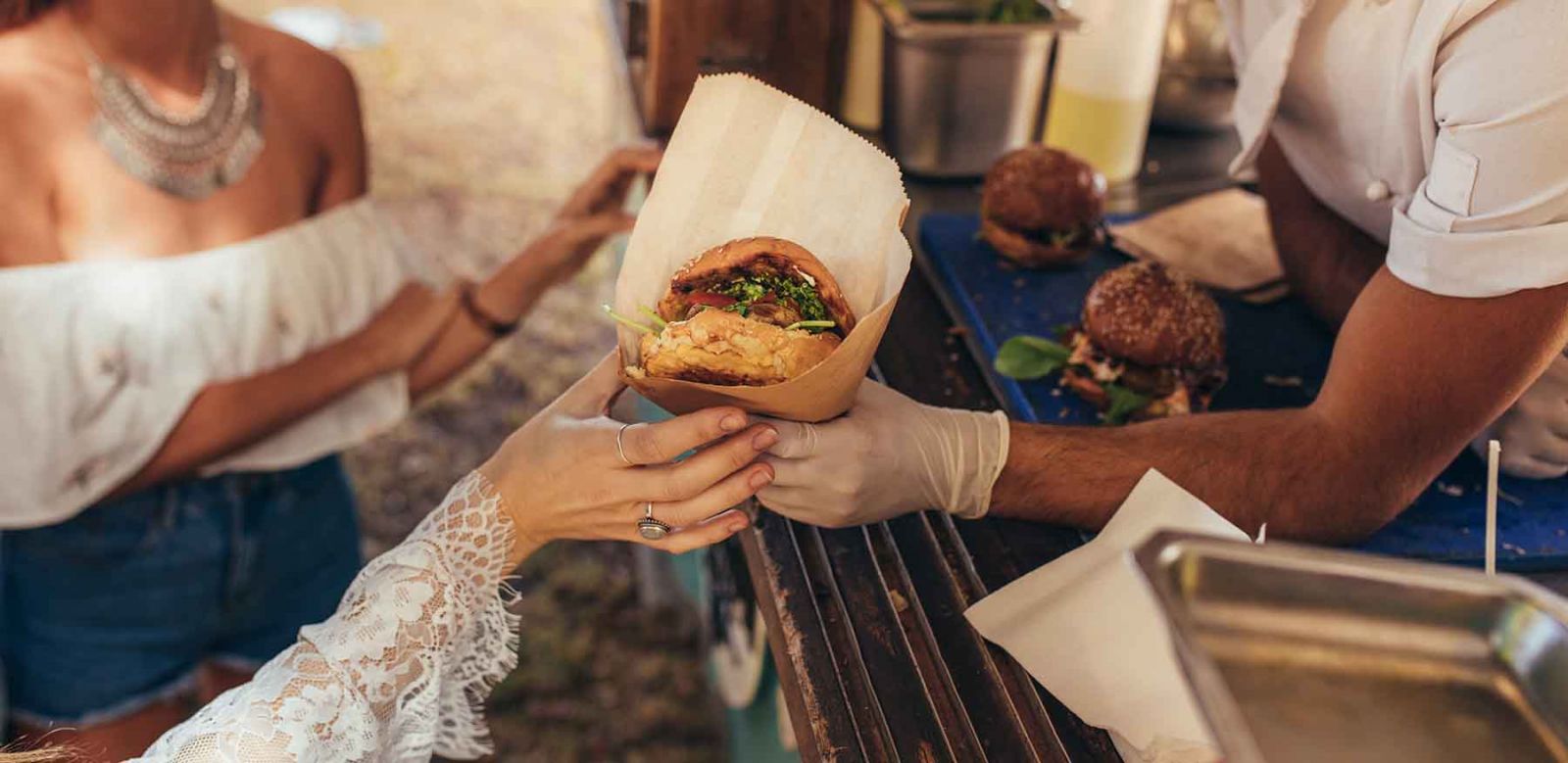 Person grabbing food from a food truck vendor