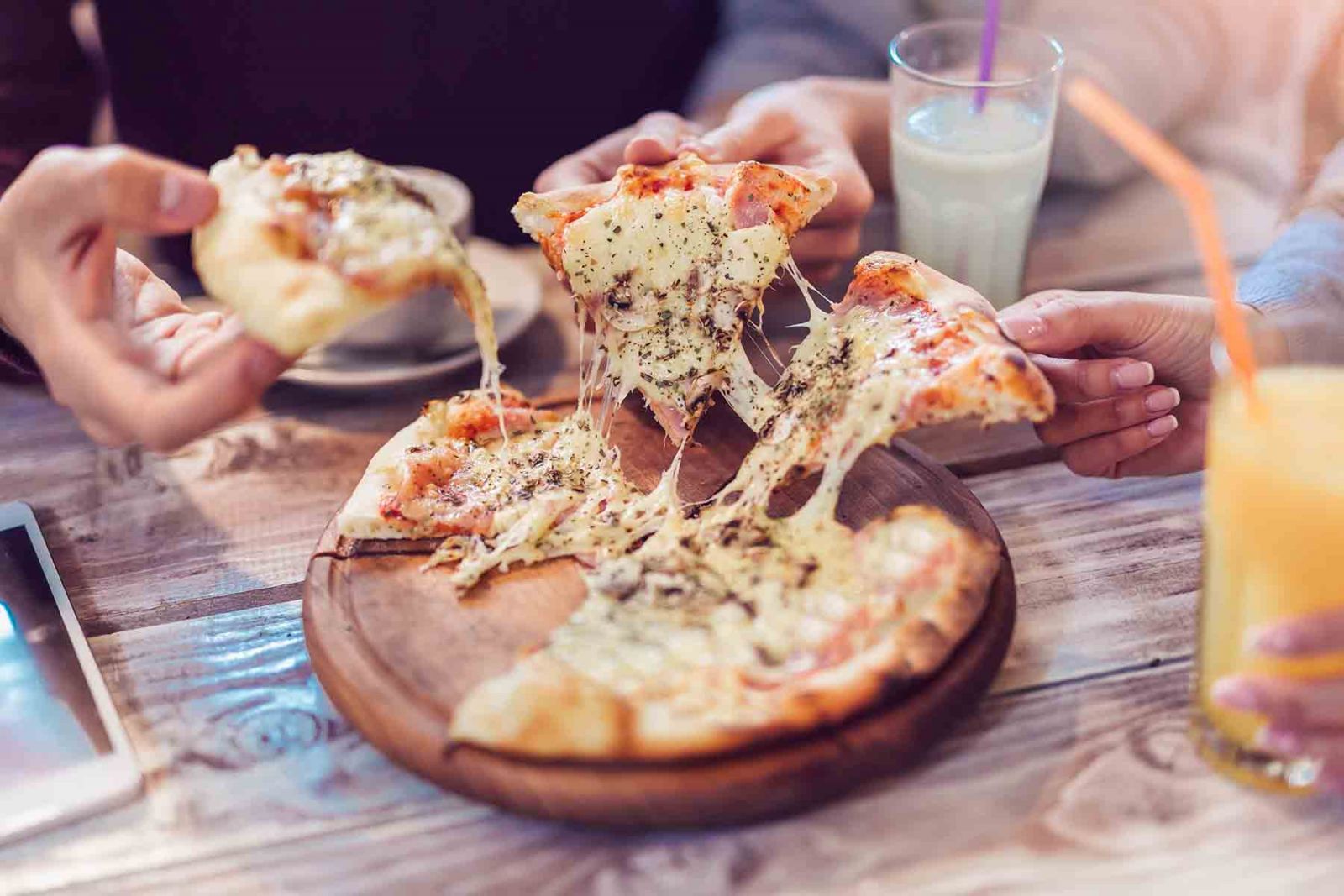 Friends enjoying cheesy pizza together