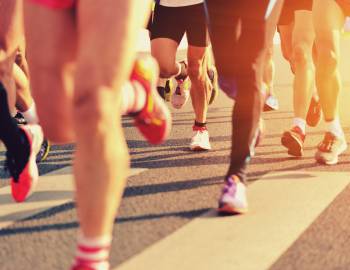 view of people's legs and feet as they run a marathon